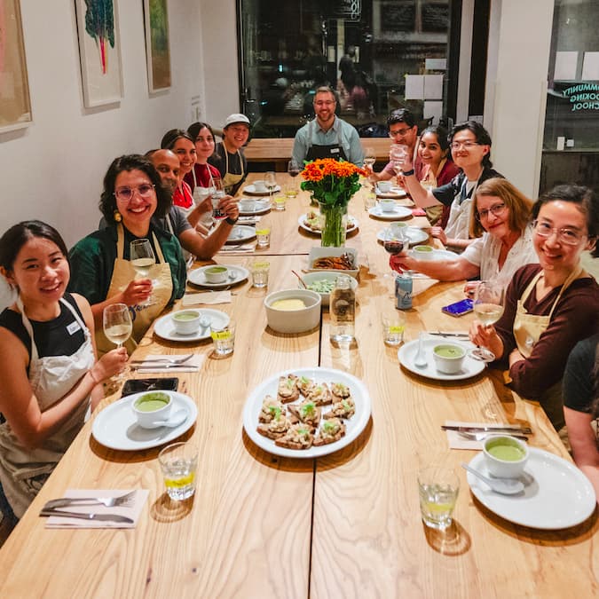 Happy diners seated around a community table 